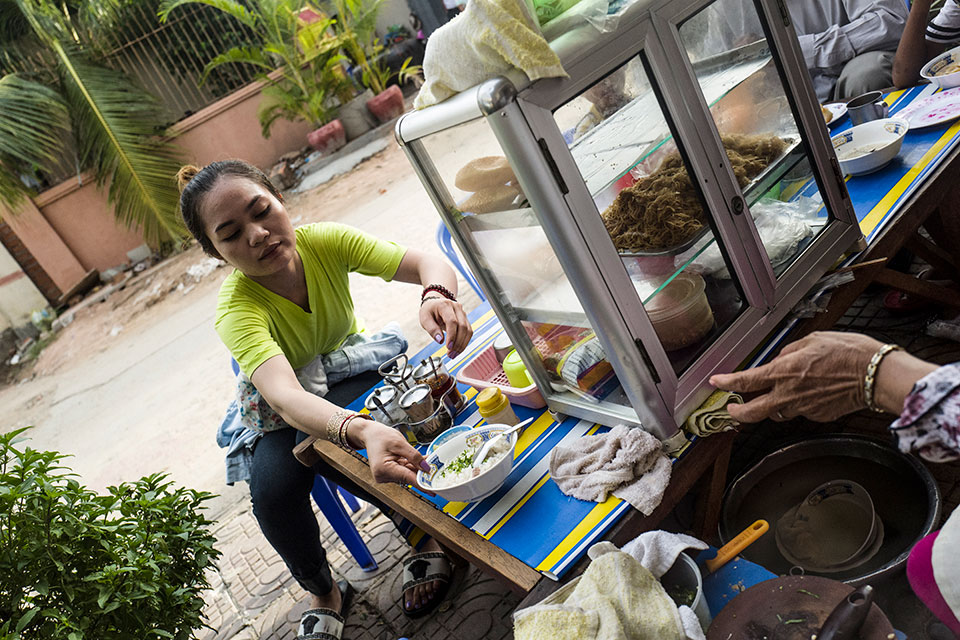 Srey Sros se detiene a desayunar en un lugar cerca del pequeño cuarto que alquila en Phnom Penh. Foto: ONU Mujeres/Charles Fox.