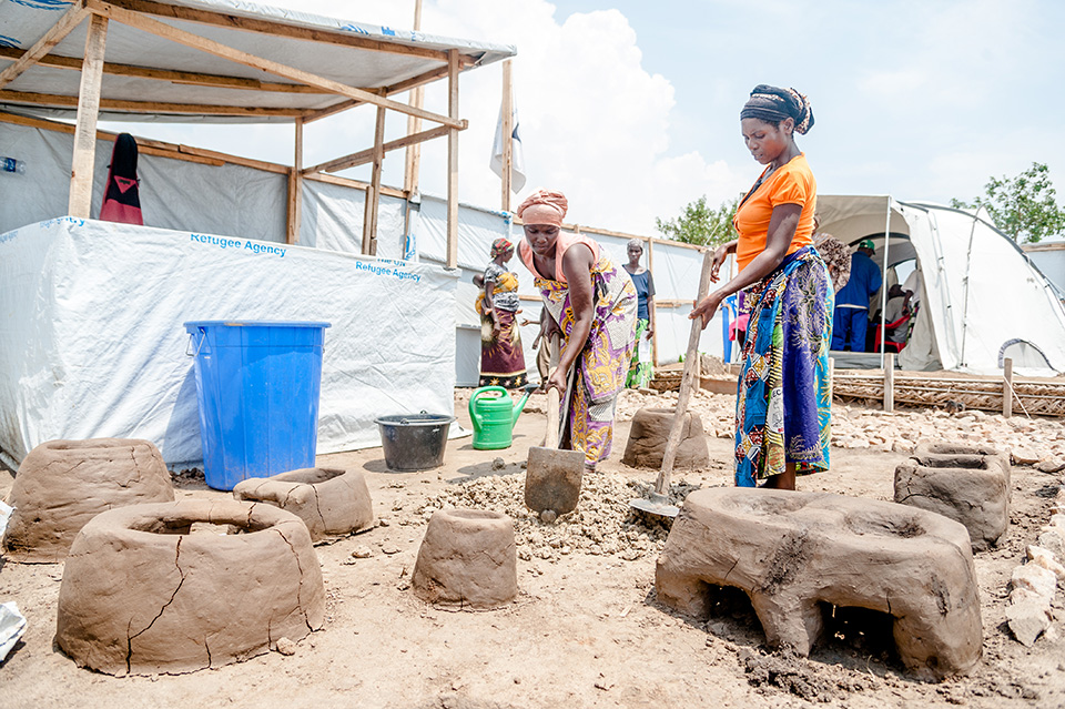 Luscie, left, and Marita, right, work to make a handmade clay stove. At the multipurpose centres, they’ve learned to make stoves which help cut the cost of feeding their families. “It takes less charcoal and the surface stays hot longer,” says Marita.  Photo: UN Women/Catianne Tijerina